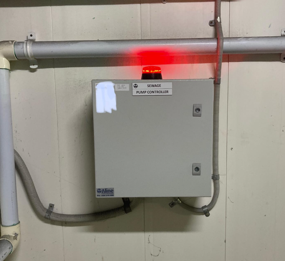 Sewage pump controller panel with alarm light activated