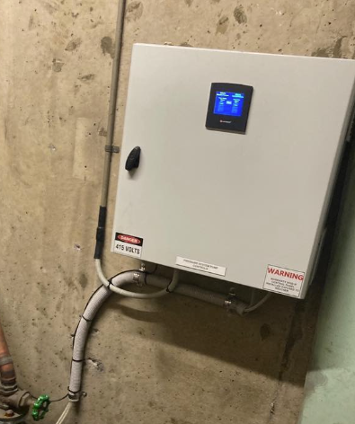 Hot water pump control panel with copper pipework connection