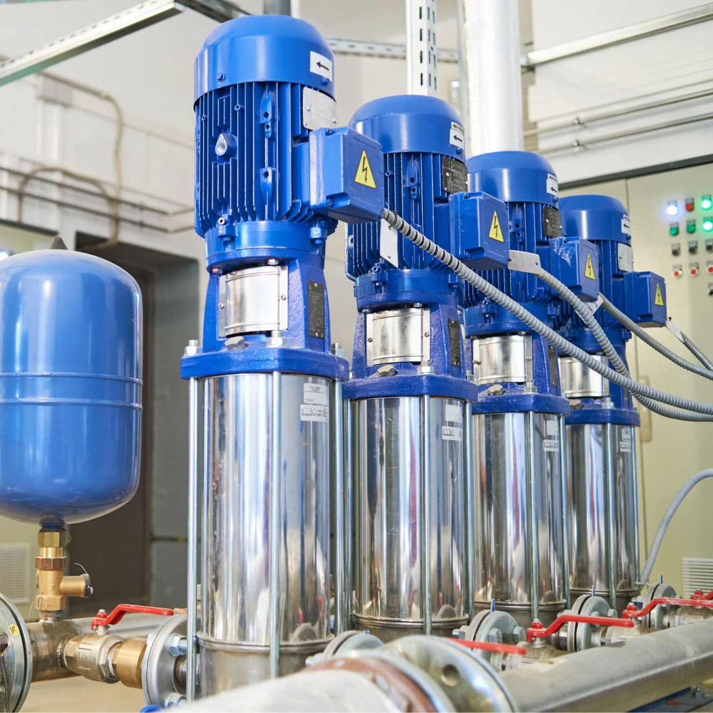 Blue industrial water pumps in a facility.