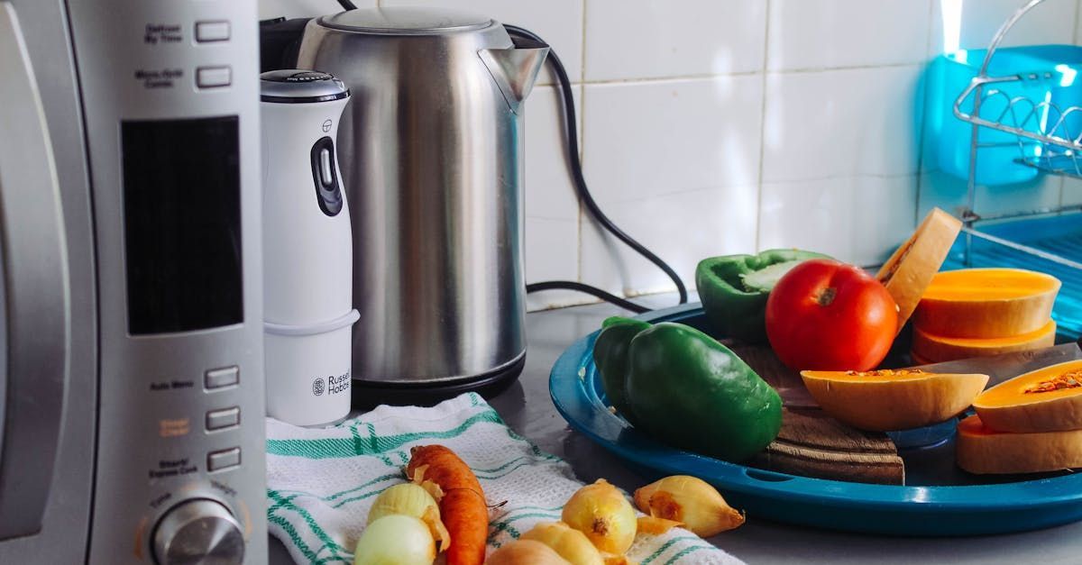 A microwave oven is sitting on a counter next to a plate of vegetables.