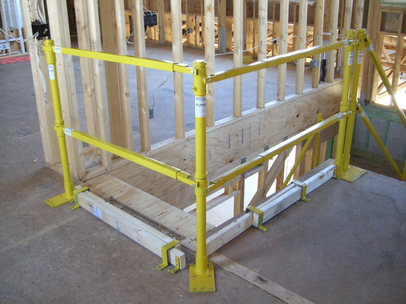 Yellow safety barrier around an open stairwell on a construction site