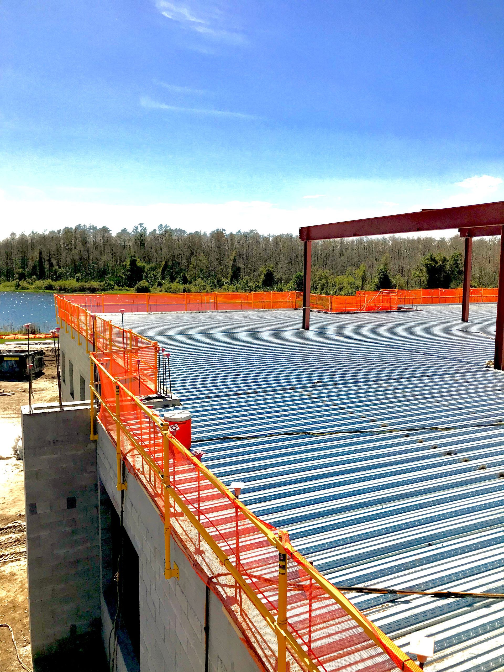 Outdoor rooftop deck with orange railings and a blue-and-white spiral pattern on the floor under a clear sky