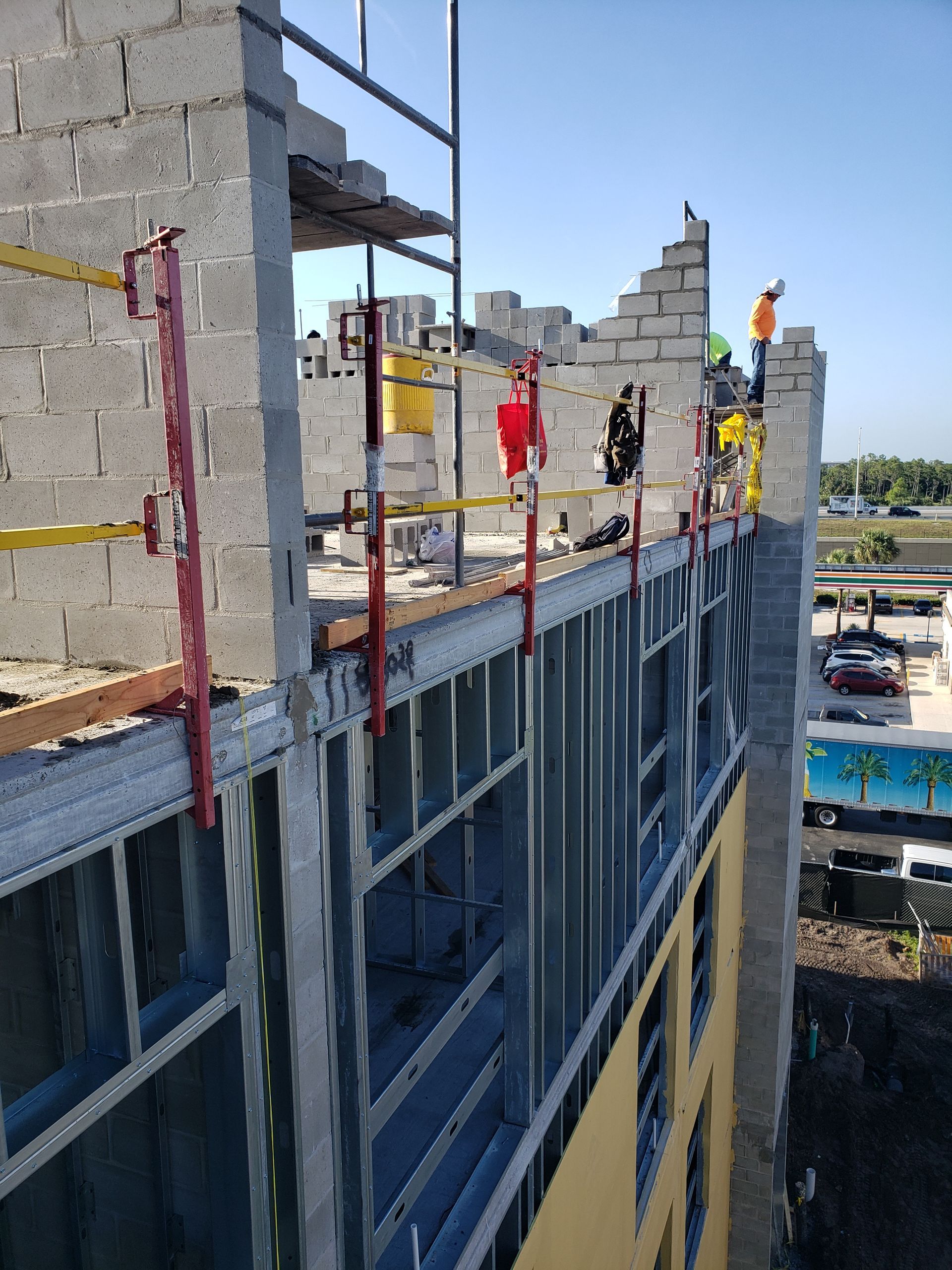 Construction workers on a building rooftop with scaffolding and a city view in the background