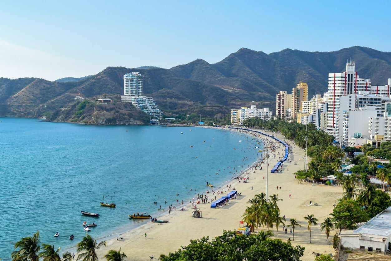 Una playa pintoresca con arena dorada, grandes rocas en aguas turquesas y una cabaña de madera en la cima