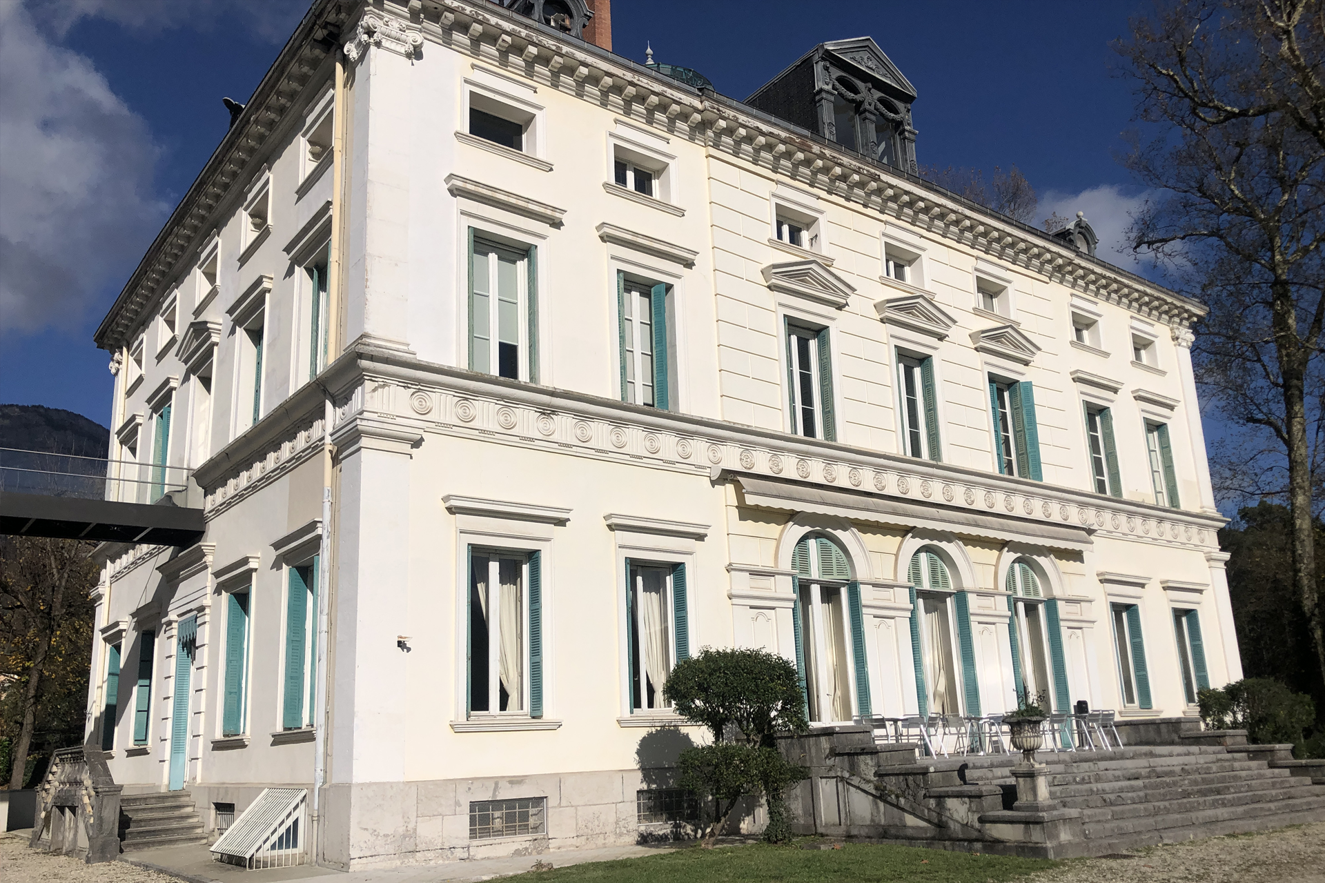Un grand bâtiment blanc avec beaucoup de fenêtres et d'escaliers devant.