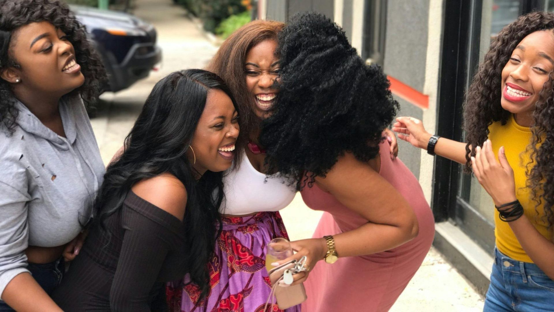 A group of women are standing next to each other and laughing.