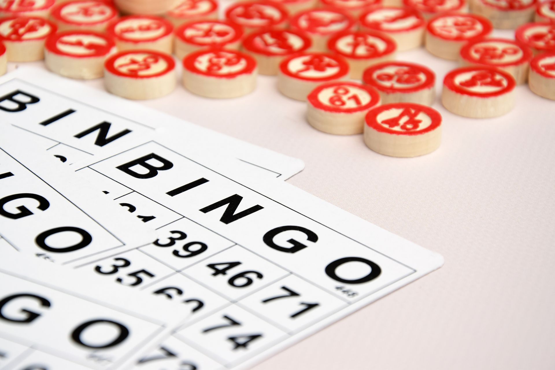Bingo cards with red-and-white chips scattered on a table