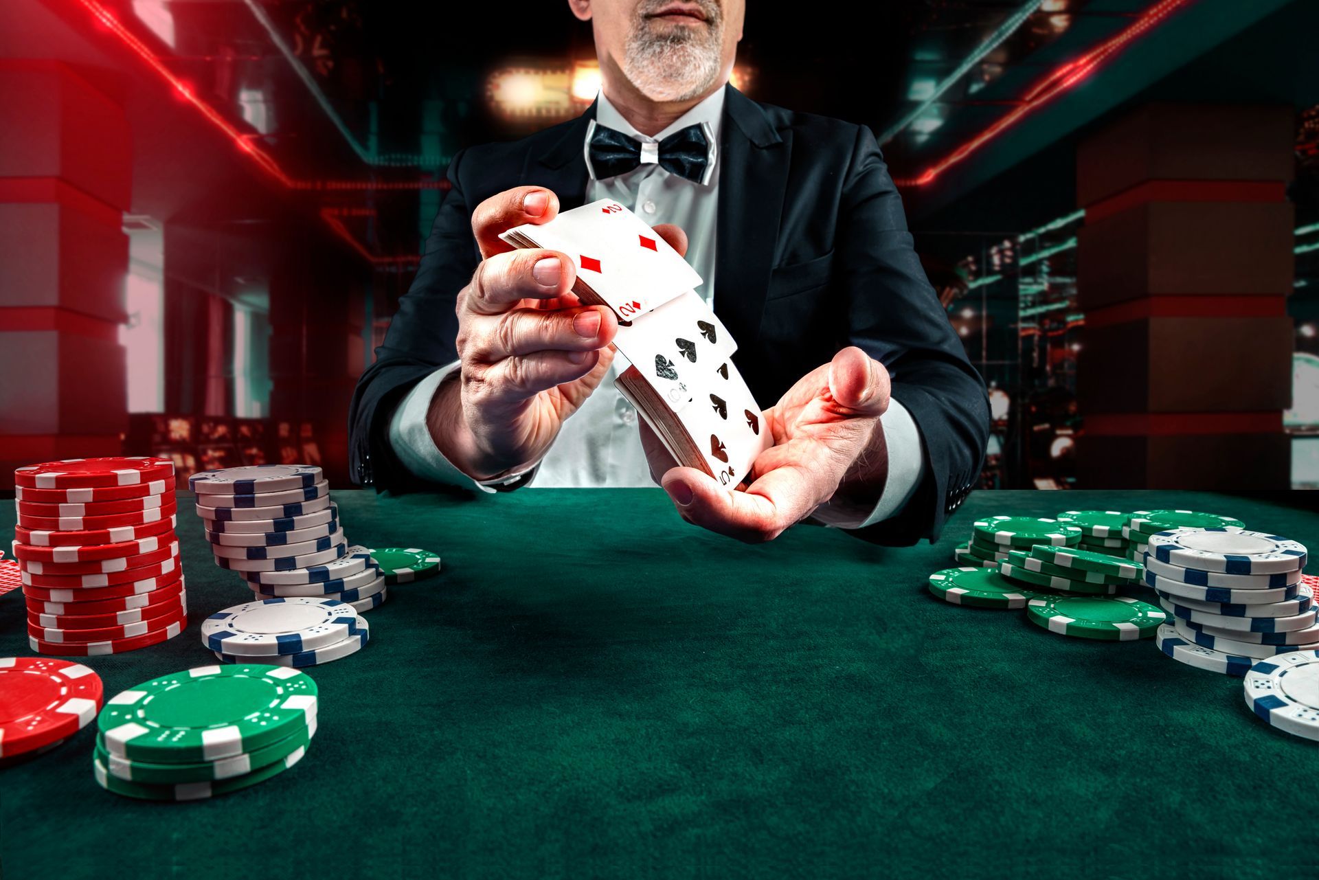 Dealer fanning playing cards over a green poker table with stacks of red, white, and green chips