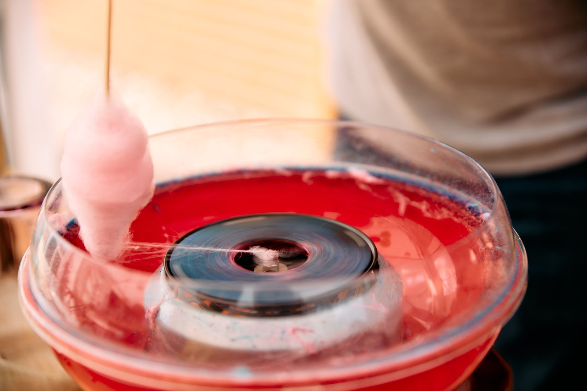 Cotton candy being spun in a red carnival machine