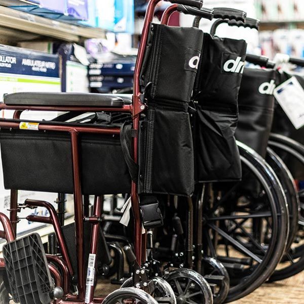 Rows of black and red wheelchairs stacked indoors in a store or storage area