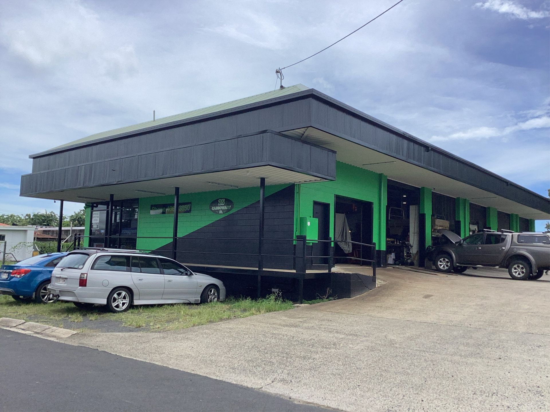 Green and black auto shop building with cars parked outside — Innisfail Pro Motors in Innisfail, QLD