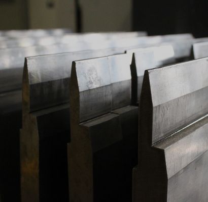 File di travi metalliche impilate in un'area di stoccaggio industriale