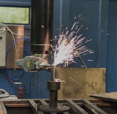 Una smerigliatrice che taglia il metallo con scintille brillanti in un'officina industriale.