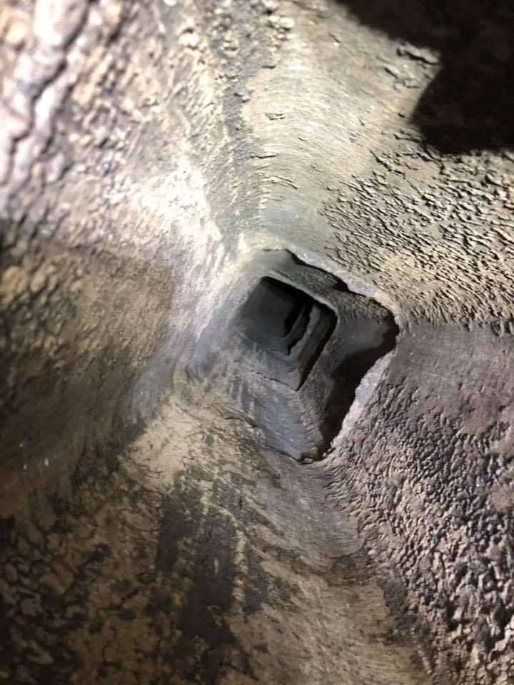 A close up of a hole in the ground in a cave.