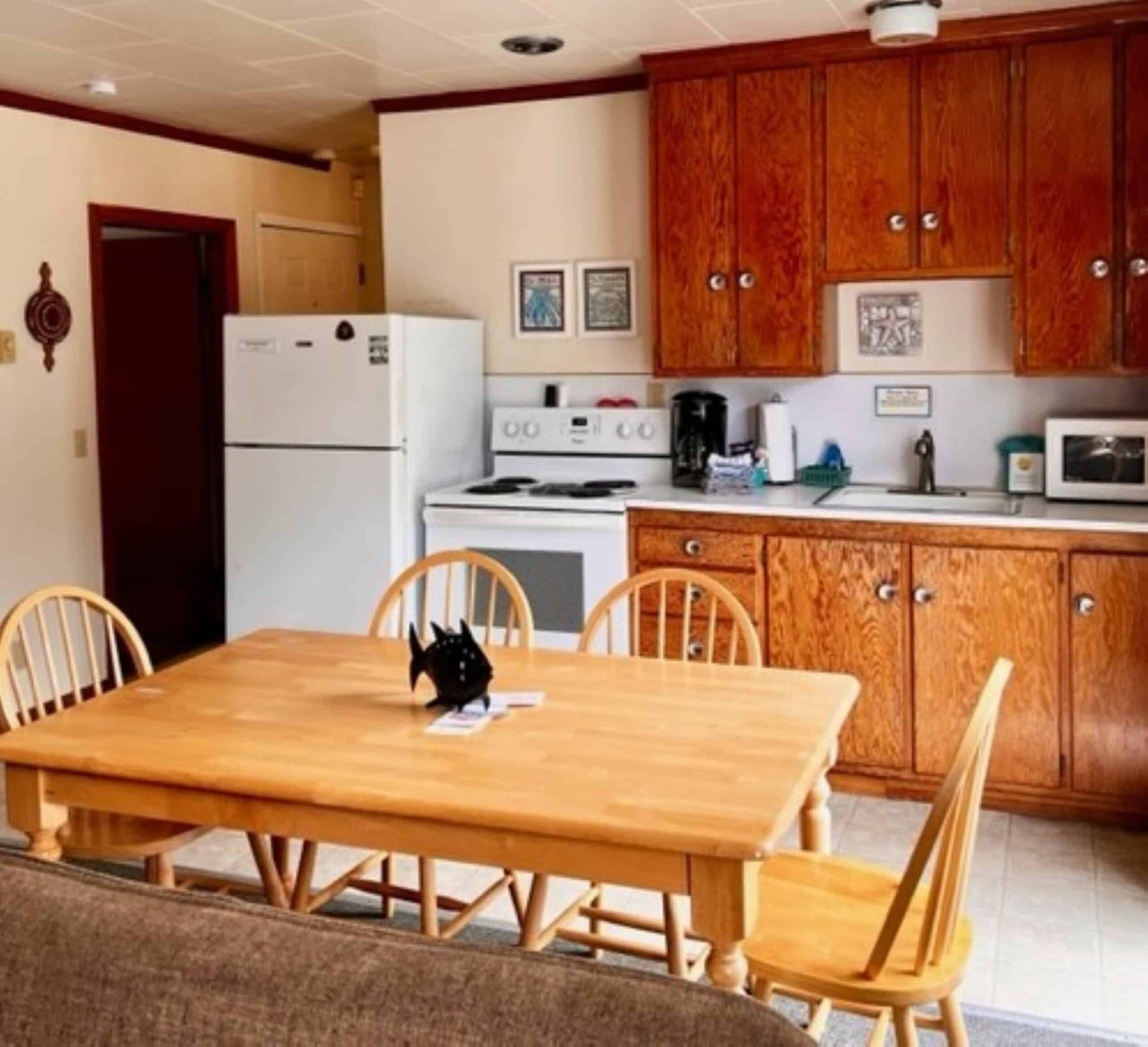 A kitchen with a table and chairs and a refrigerator