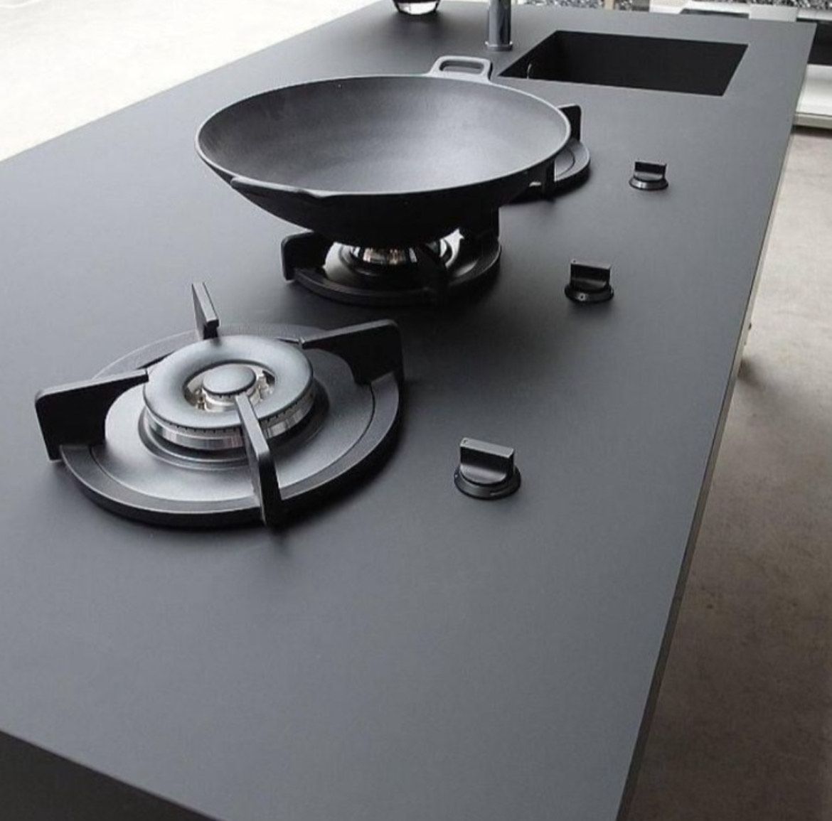 Porcelain countertop with integrated gas stove, modern, high-end kitchen design.