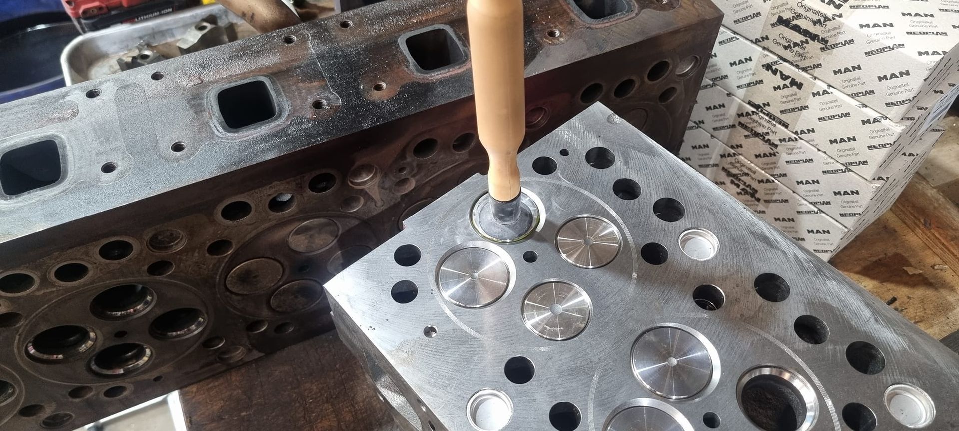 A Tool Manually Grinding a Valve Seat on a Refurbished Metal Engine Cylinder Head — B & W Commercials In Laurieton, NSW