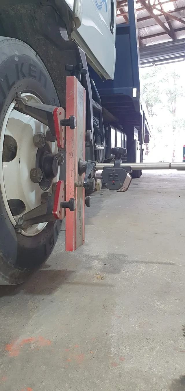 Close-up of a truck wheel with a red wheel lock in a covered garage area