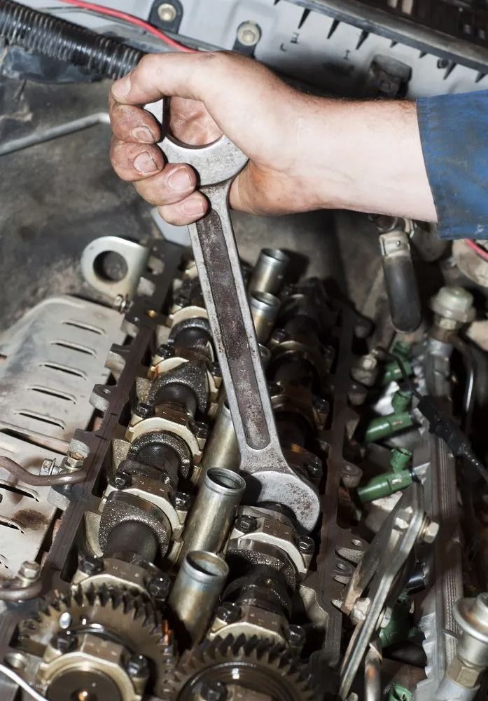 A Person's Hand Using a Large Metal Wrench to Adjust Components — B & W Commercials In Laurieton, NSW