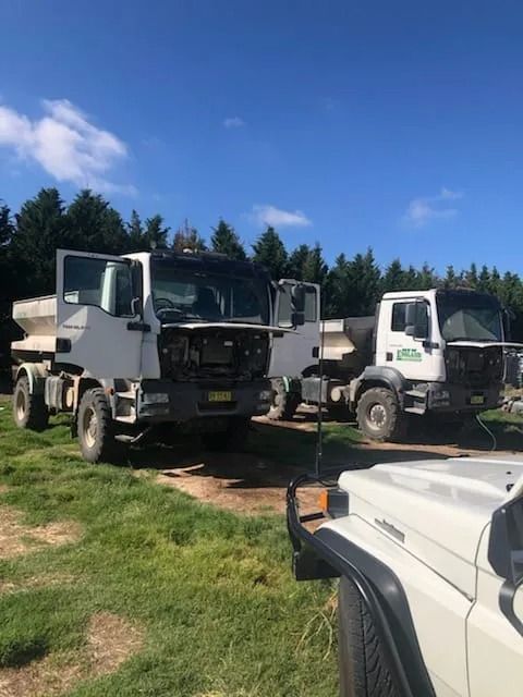 Two White Dump Trucks With Open Doors and Hoods — B & W Commercials In Wauchope, NSW