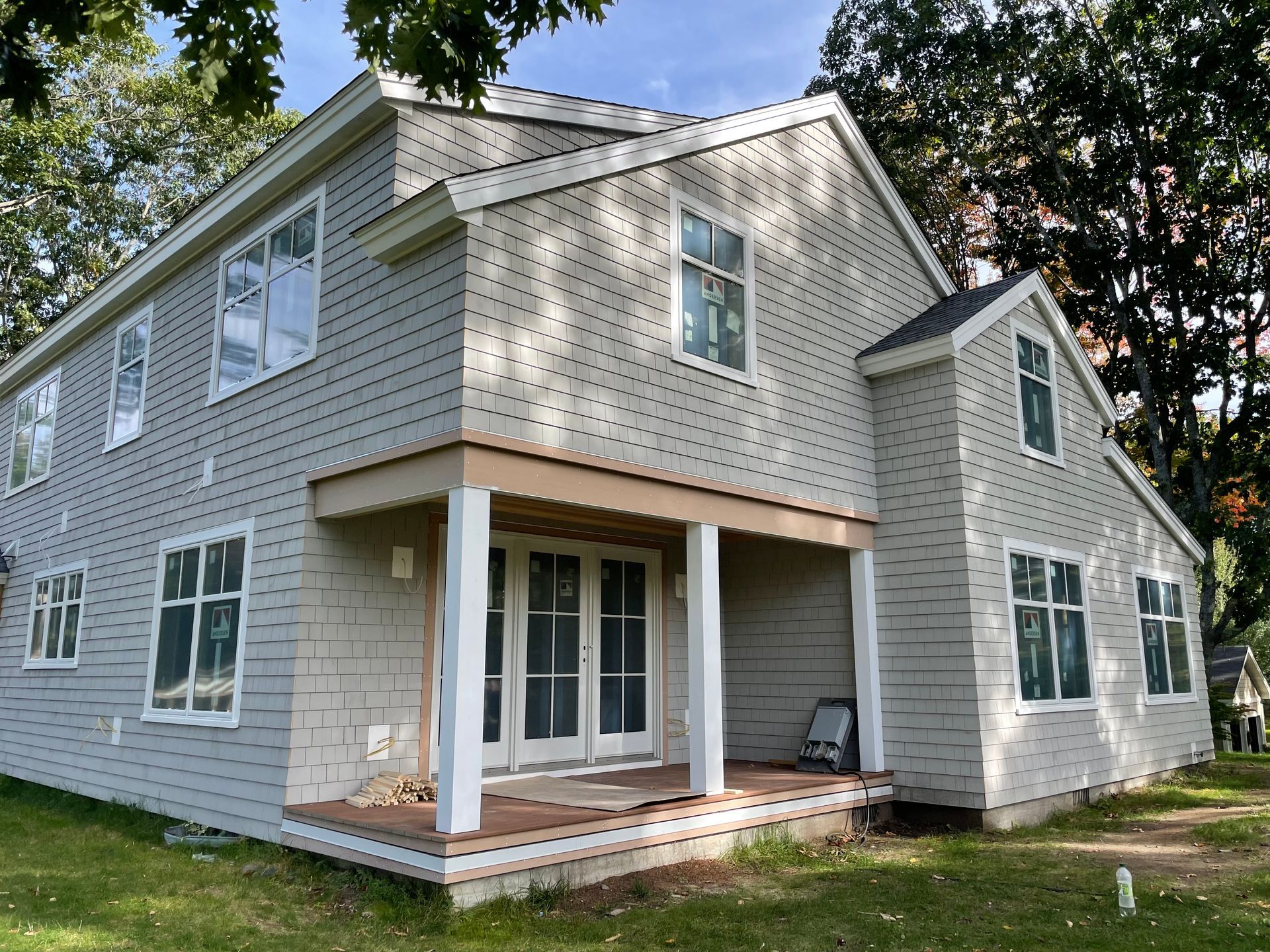 Two-story house with gray siding, white trim, and a small covered porch.