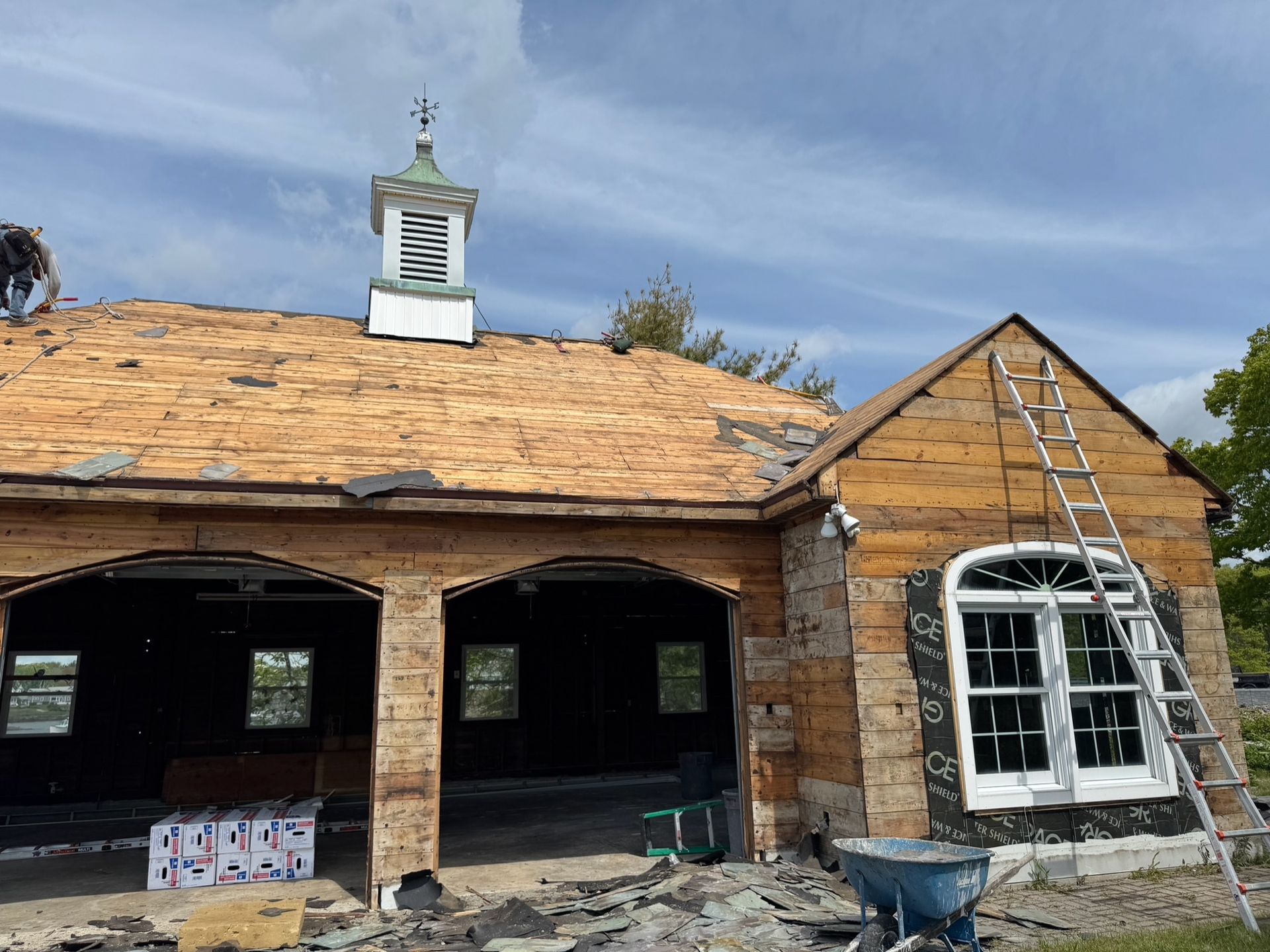 House under construction, wood frame with scaffolding. Windows and siding being added.