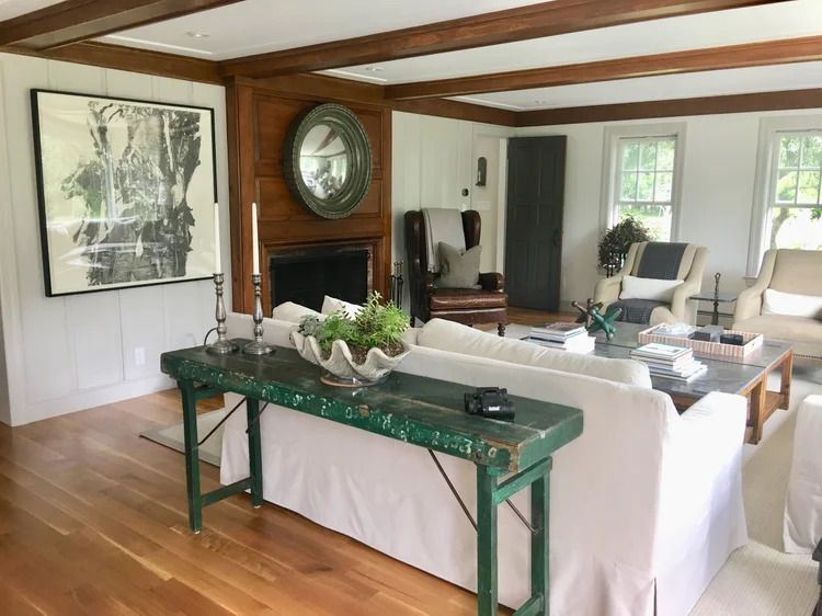 Living room with white sofas, fireplace, and green accent table.