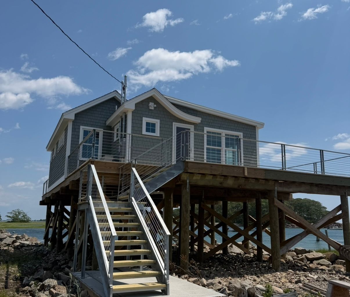 Two-story house with gray siding, white trim, and a small covered porch.