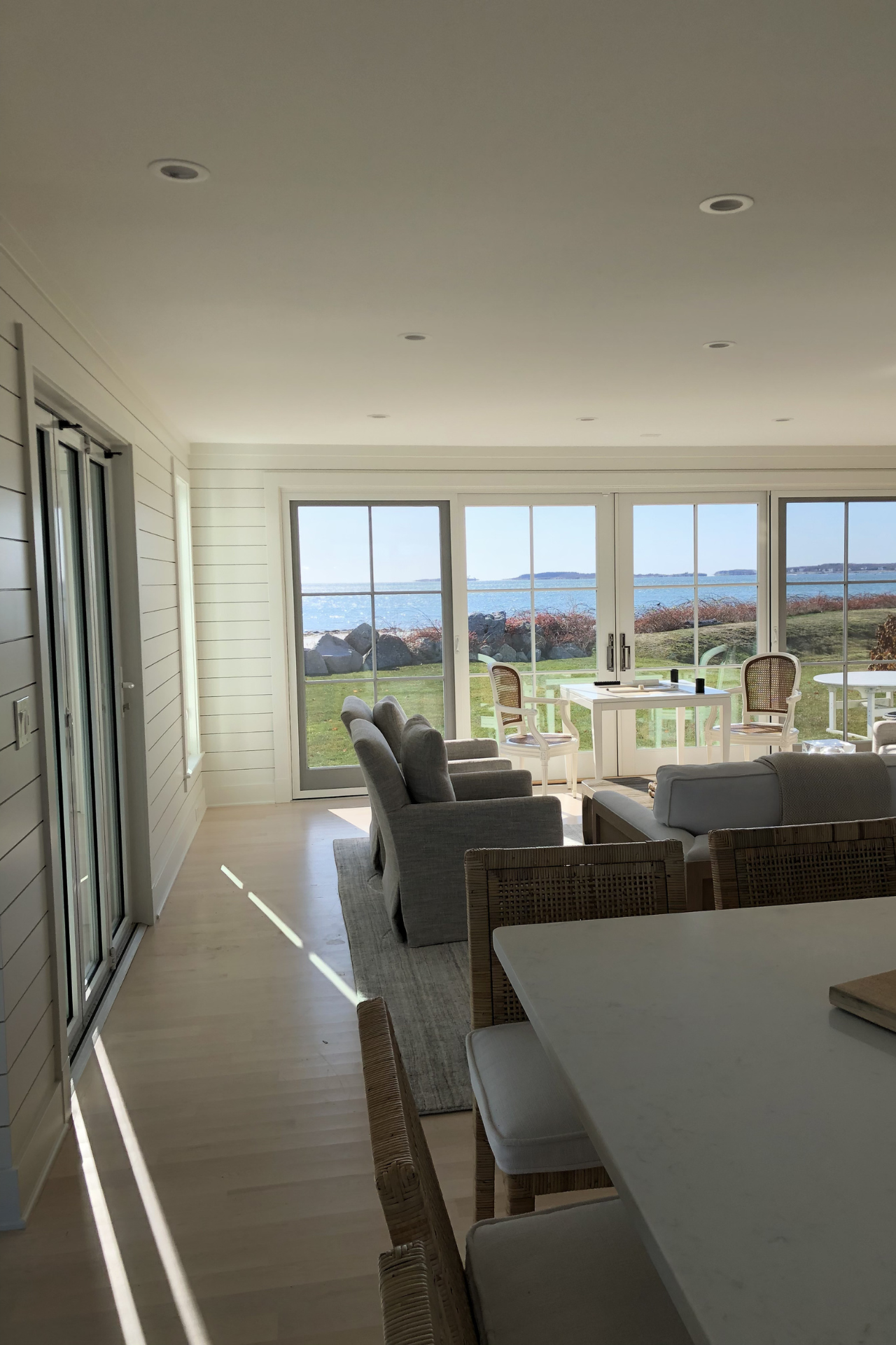 Bright, airy living space with ocean view, white walls, large windows, and contemporary furniture.