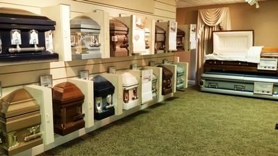 Funeral showroom with rows of caskets in a carpeted display room
