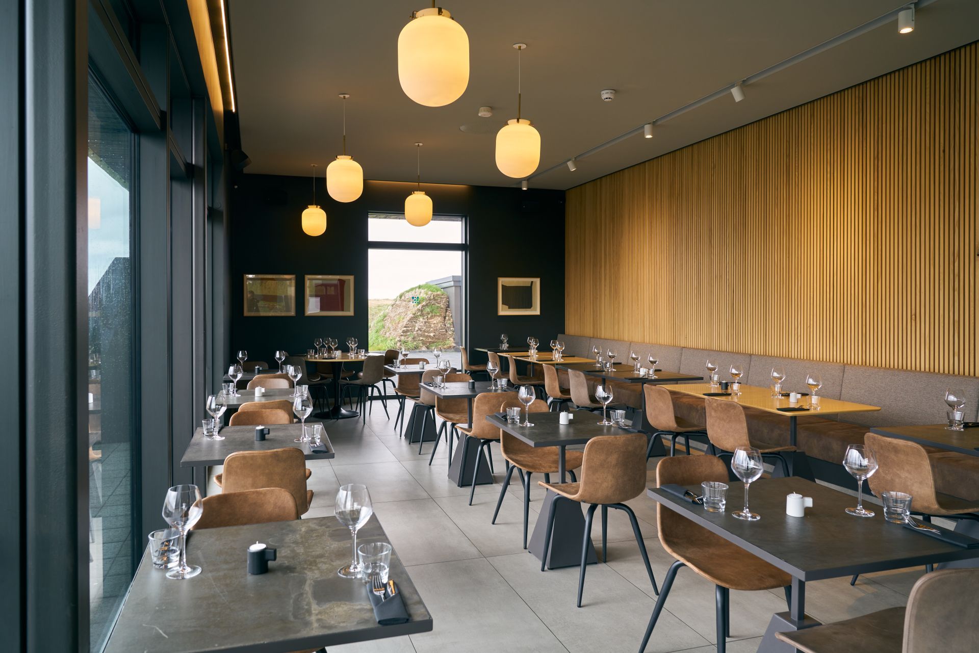 a restaurant with tables and chairs and a large window at Krauma Geothermal