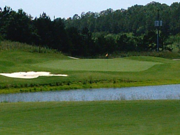 A golf course with a pond in the middle of it