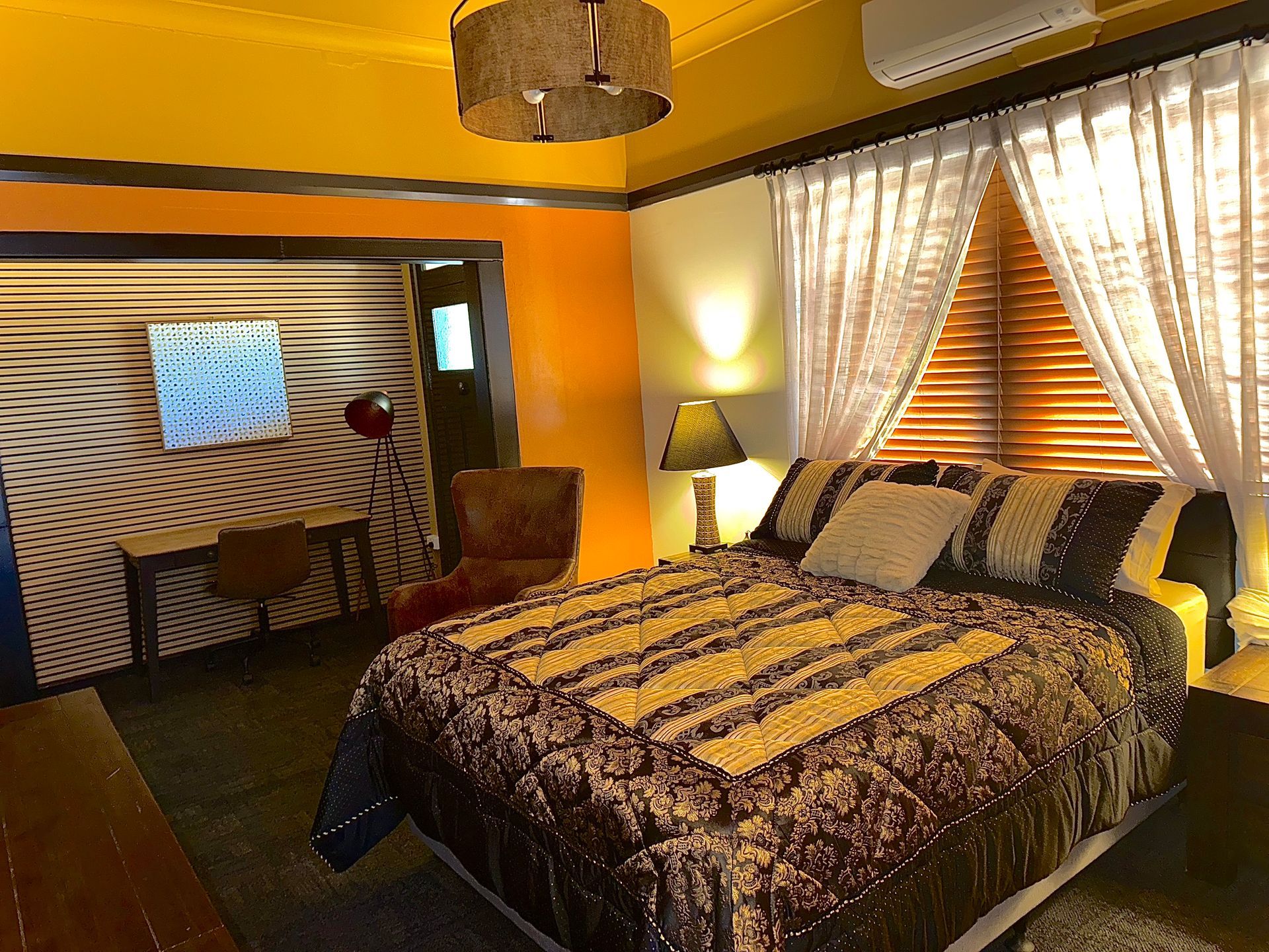 A bedroom with a king size bed and a television on the wall