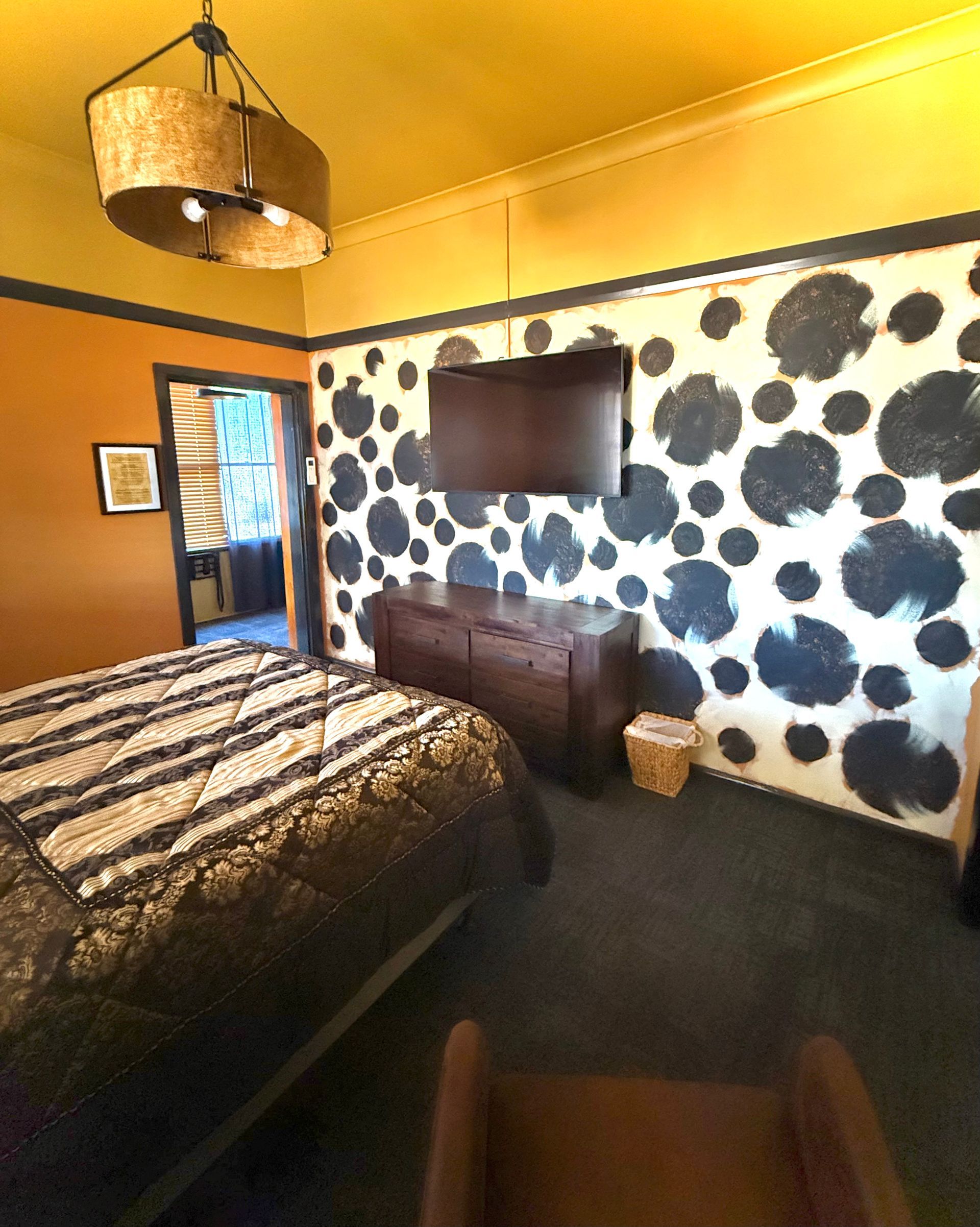 A bedroom with a bed and a television on the wall