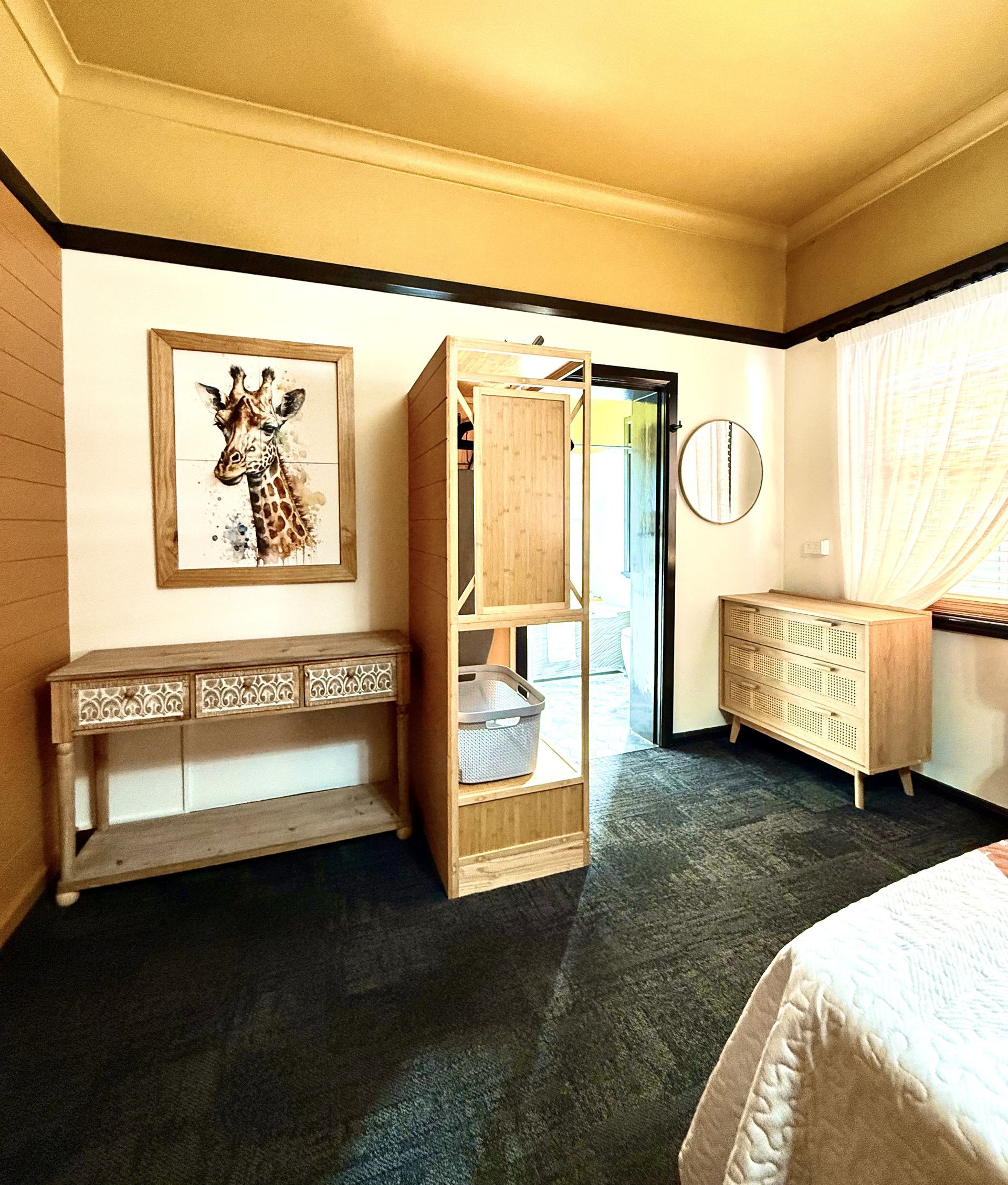 A bedroom with a picture of a giraffe on the wall