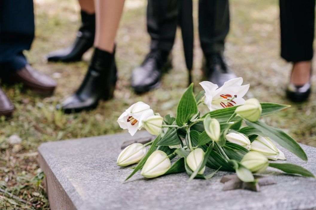 White lilies placed on a gravesite during a funeral service for families in Sterling, IL