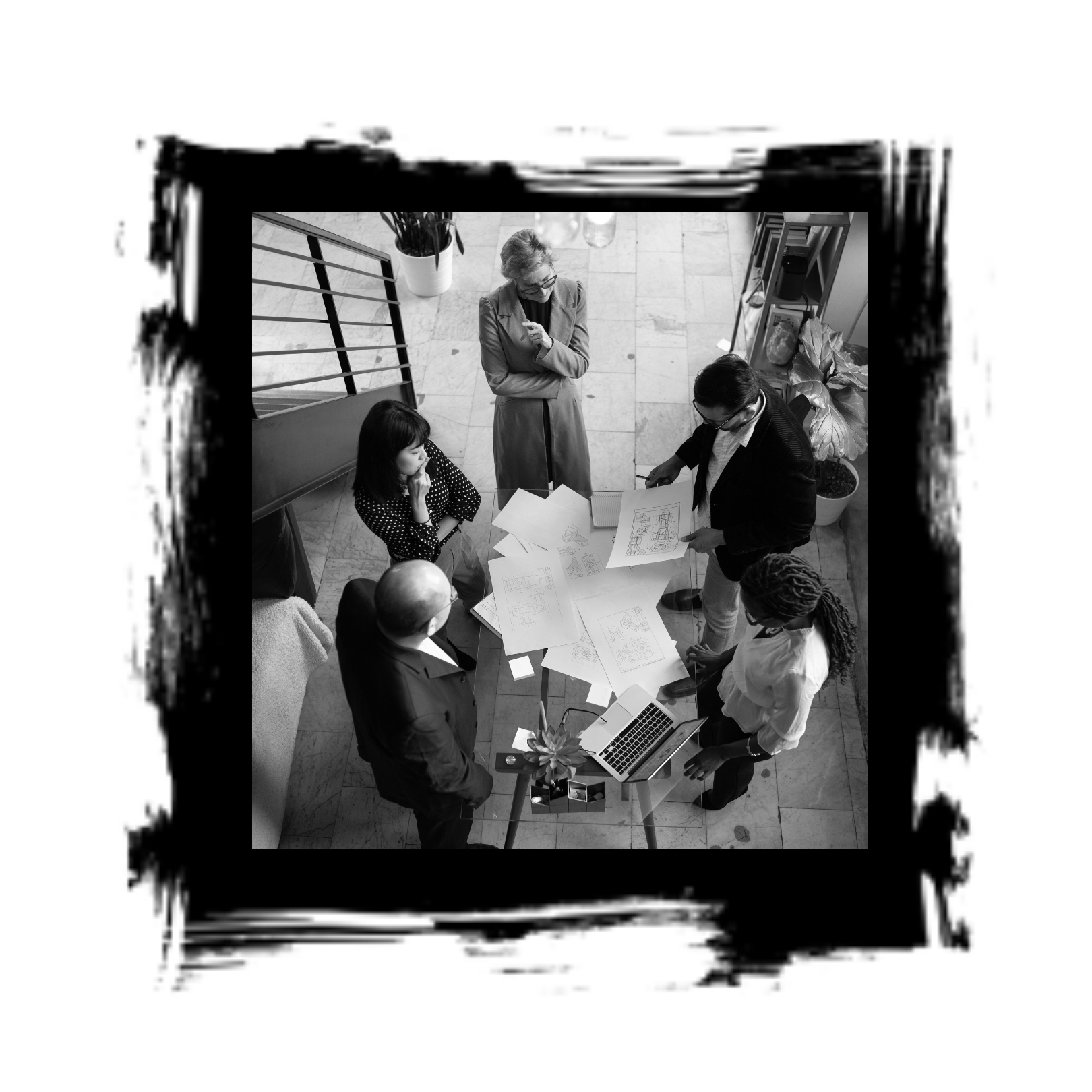 Group of people gathered around a table, reviewing plans. Overhead view, black and white.