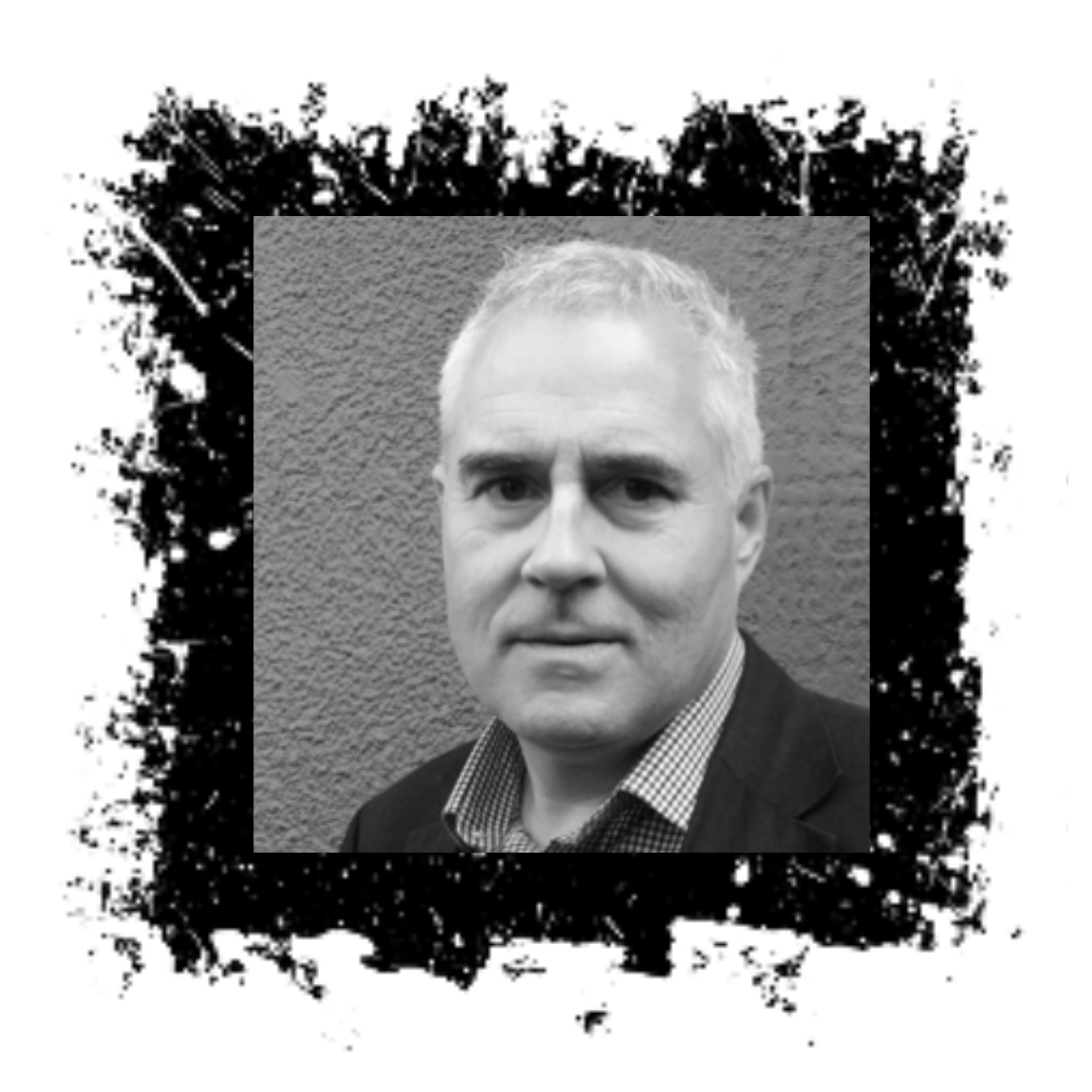 Man with gray hair in a black blazer, against a gray wall, inside a black splatter-painted square.