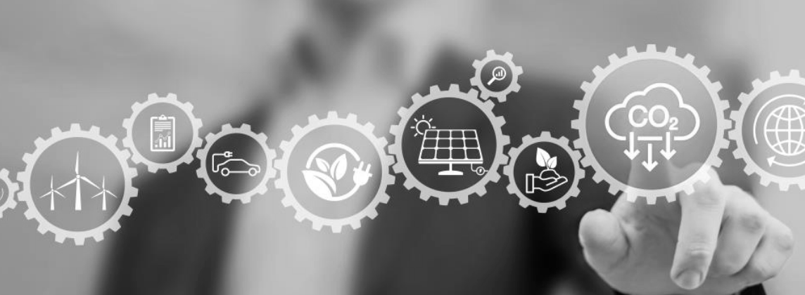 Person's hand pointing at a carbon emissions reduction graphic, composed of gears with environment icons.