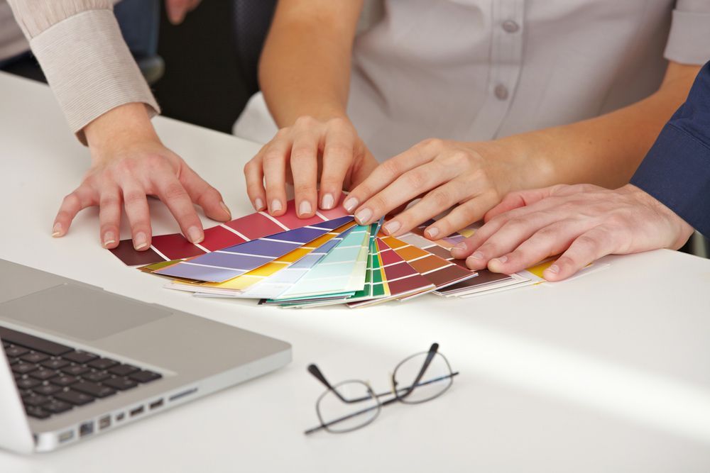 A Group of People Are Looking at A Color Chart on A Table — Rodney Lees Cabinetmaking In Mullumbimby, NSW