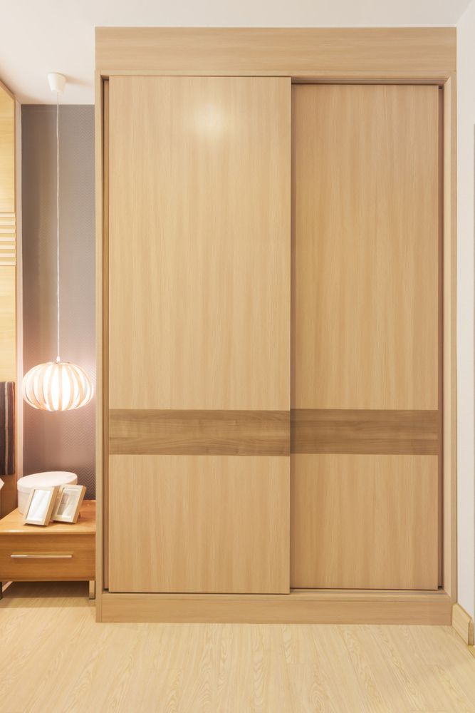 A Wooden Wardrobe with Sliding Doors in A Bedroom — Rodney Lees Cabinetmaking In Mullumbimby, NSW