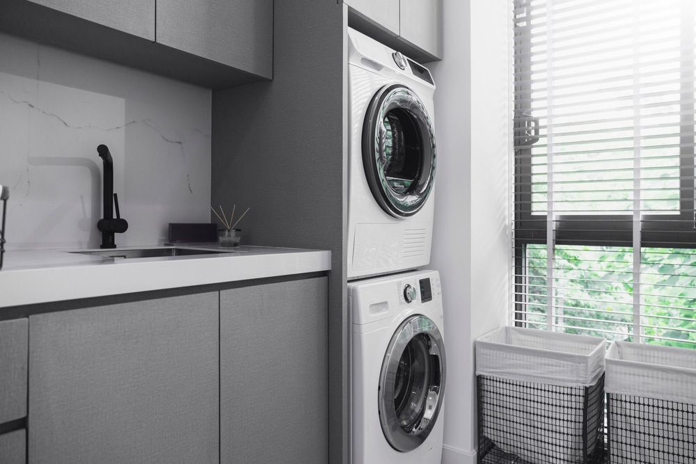 A Laundry Room with A Washer and Dryer Stacked on Top of Each Other — Rodney Lees Cabinetmaking In Ocean Shores, NSW