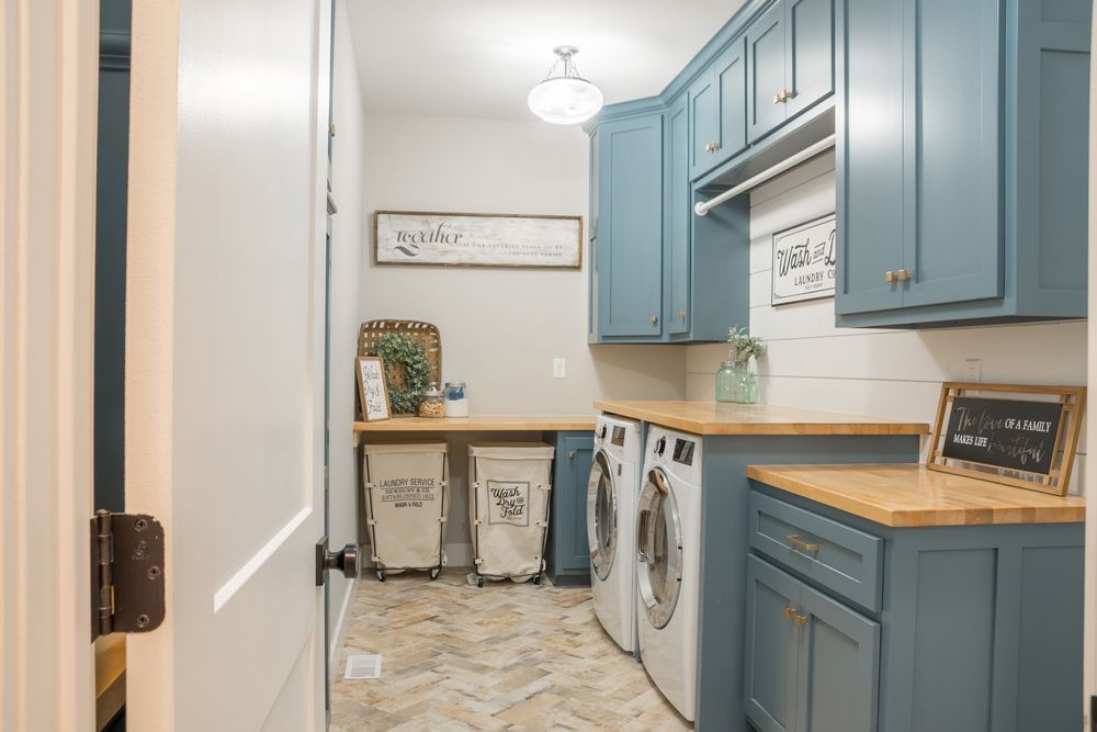 A Laundry Room with Blue Cabinets and White Appliances — Rodney Lees Cabinetmaking In Byron Bay, NSW