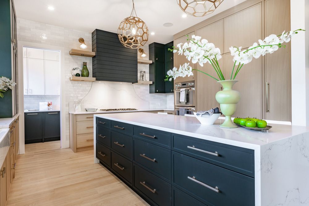 A Kitchen with A Large Island and A Vase of Flowers on The Counter — Rodney Lees Cabinetmaking In Alstonville, NSW