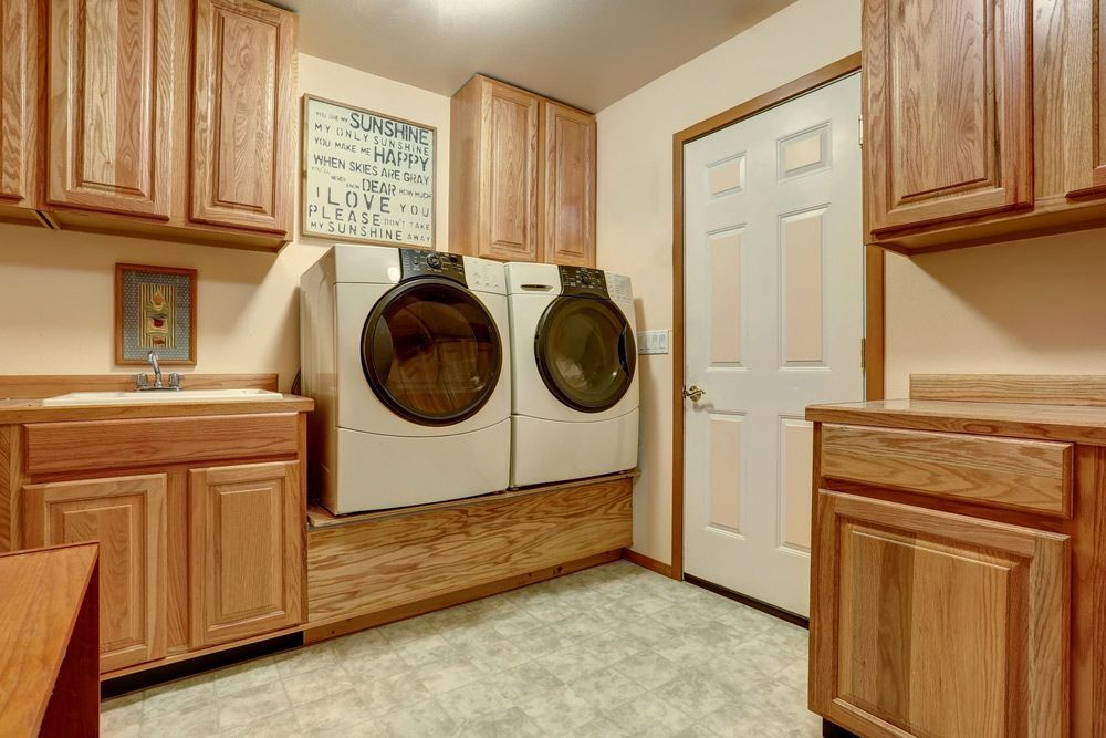 A Laundry Room with A Washer and Dryer and Wooden Cabinets — Rodney Lees Cabinetmaking In Mullumbimby, NSW