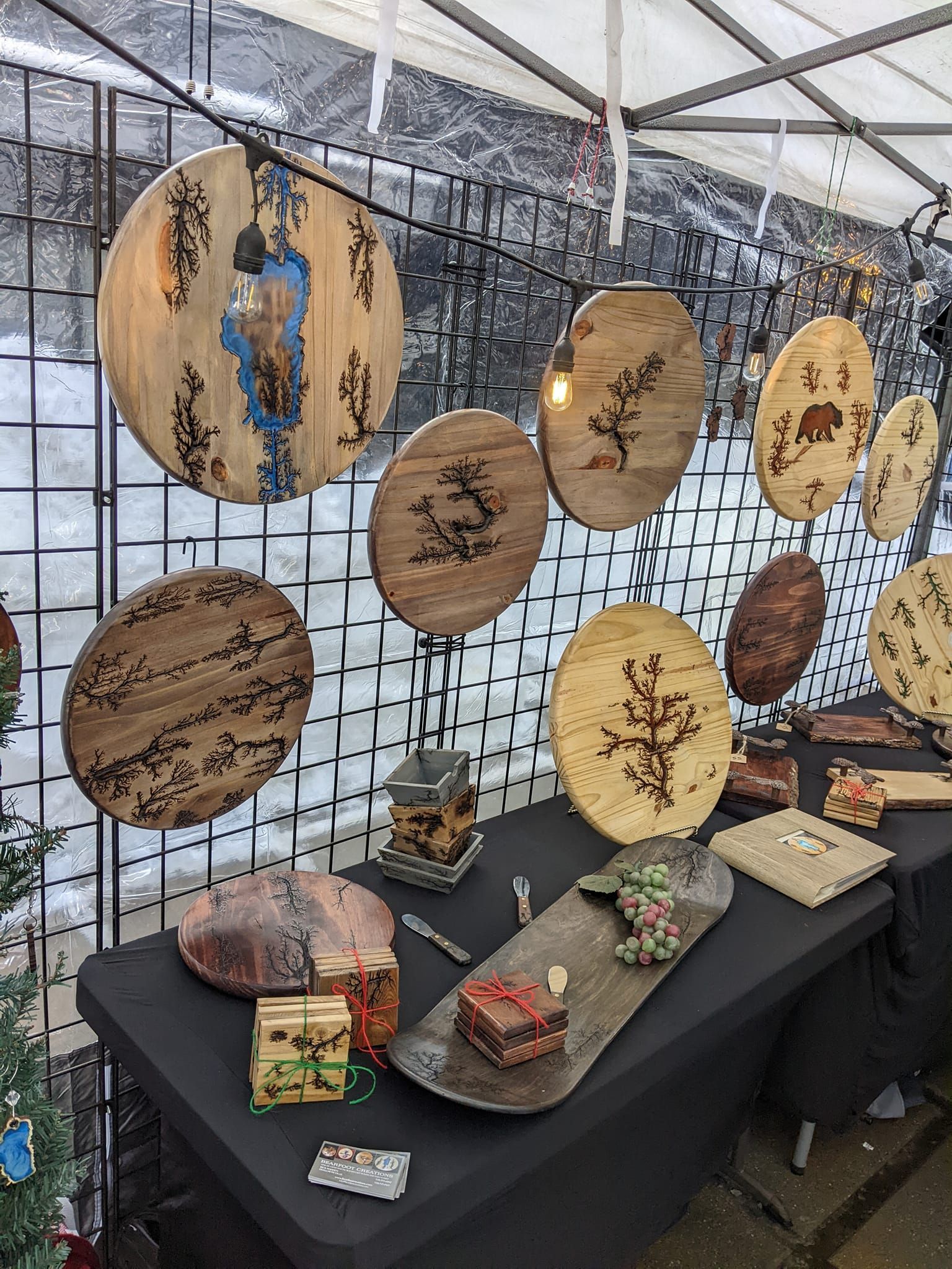 Wooden art display with round and rectangular pieces, some with burnt designs.