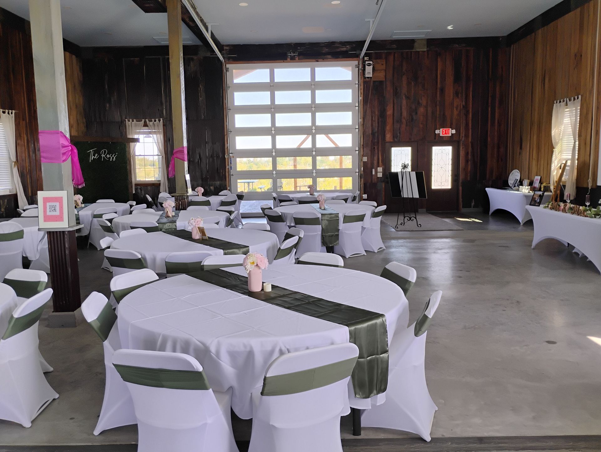 Empty banquet hall with round tables, white tablecloths, and chairs, set up for an event