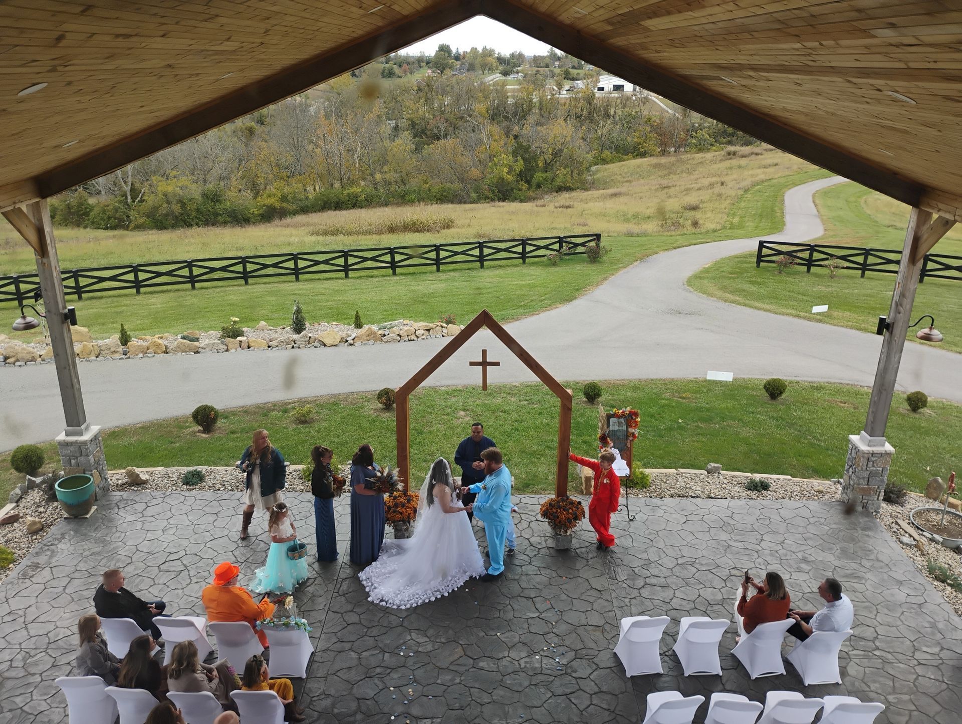 Wedding ceremony under a pavilion with guests seated and the bride and groom at an outdoor altar.