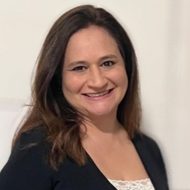 A woman is smiling for the camera while wearing a black jacket and white lace top.