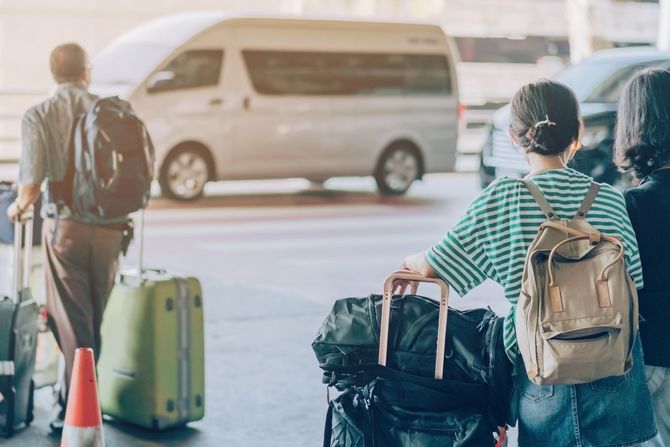 A group of people are walking with luggage at an airport.